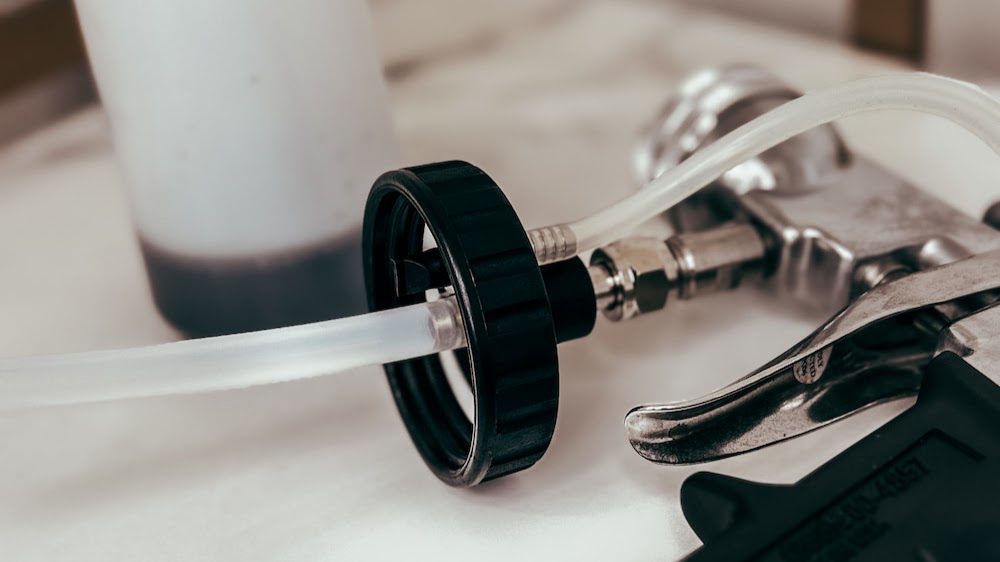 Close-up of a professional airbrush spray tan gun at 33 Esthetics studio