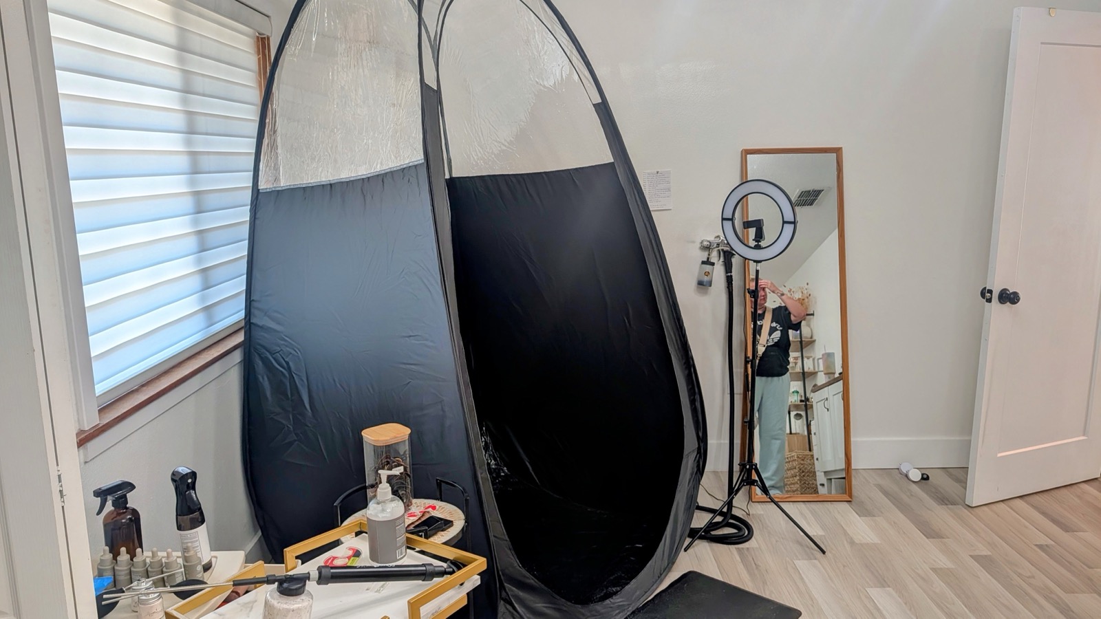 Custom spray tan studio at 33 Esthetics — airbrush setup, pop-up tent, and tools in a private one-room studio in Longwood, FL
